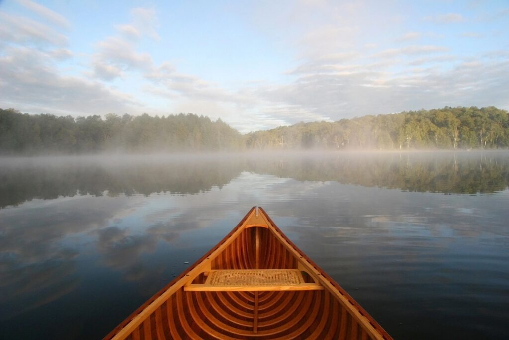 A boat is in the water on a foggy day.