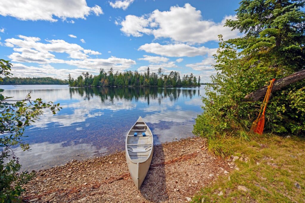 A canoe on the shore of a lake.